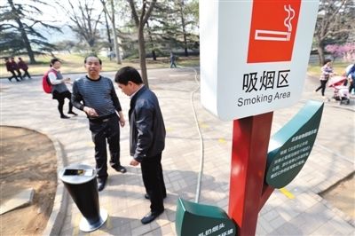 月1日，北京动物园，两位游客在吸烟区抽烟。“京版”控烟条例草案拟规定室内公共场所全面禁烟。新京报记者 薛珺 摄