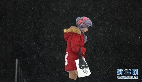 12月10日,一位沈阳市民走在雪中。